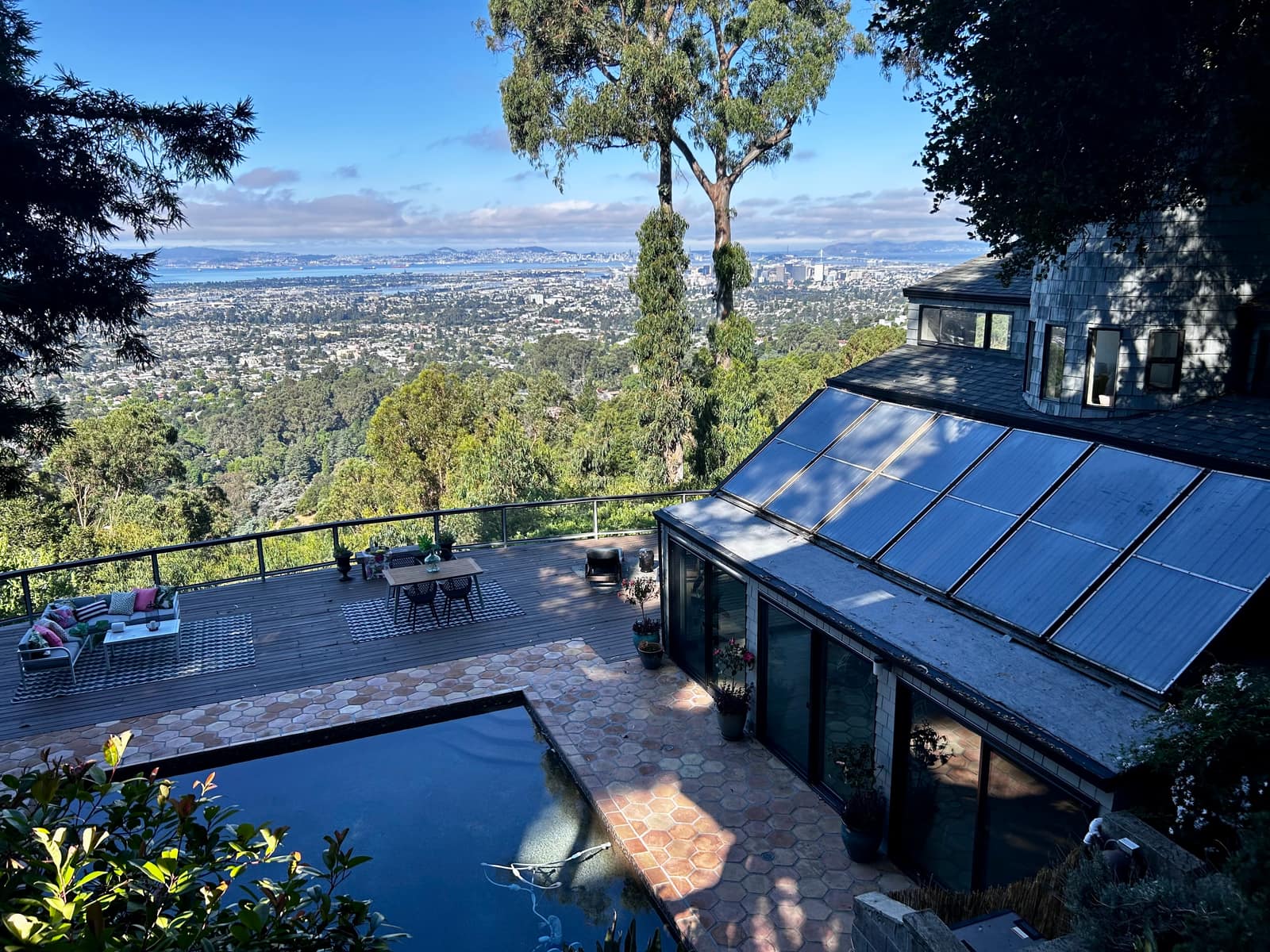 An Oakland hills home with a pool and a wide deck, looking out over Oakland and the Bay to San Francisco